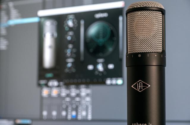 Universal Audio's Sphere LX modeling microphone is pictured infront of a PC monitor.