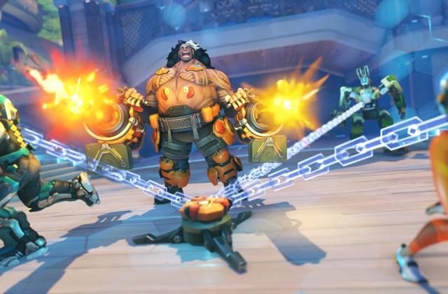 Overwatch 2 hero Mauga fires chainguns as other characters are trapped by transparent chains.