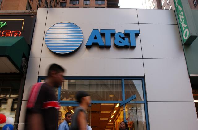 391649 04: People walk past an AT&T Wireless store July 9, 2001 in New York City. The cable company Comcast has made a bid to merge with AT&T broadband. The combination of the two corporations would create the largest broadband communications provider in the world, with approximately 22 million subscribers. (Photo by Spencer Platt/Getty Images)
