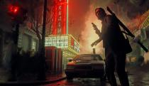 In this promo still for Alan Wake II, we see a character silhouetted in the foreground with a gun in his hand, a theater marquee and a rain-slicked street with smoke rising in the background.