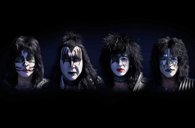 Digital avatars of Kiss current band members, Paul Stanley, Gene Simmons, Tommy Thayer and Eric Singer showing just their faces against a black background.