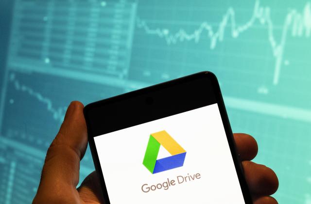 CHINA - 2023/03/16: In this photo illustration, the American file-hosting storage service company owned by Google, Google Drive, logo is seen displayed on a smartphone with an economic stock exchange index graph in the background. (Photo Illustration by Budrul Chukrut/SOPA Images/LightRocket via Getty Images)