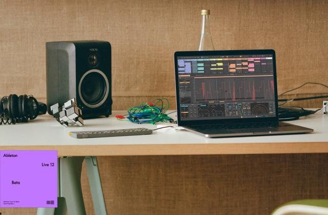 A laptop running Ableton Live 12 alongside a portable synth and a desktop monitor speaker.