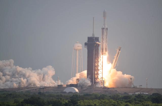 Photo of a SpaceX rocket, with the Psyche spacecraft attached to it, blasting off.
